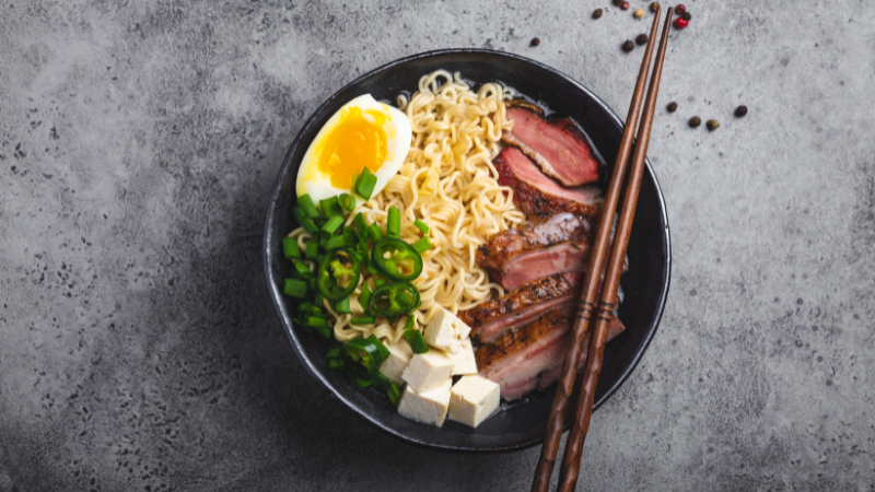 Miojo coreano com ovo, tofu, carne de porco, massa tipo lámen e cebolinha.