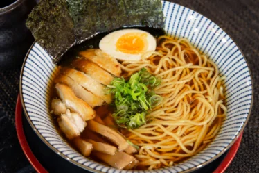 Miojo coreano do tipo lámen com frango, ovo, massa e alga.