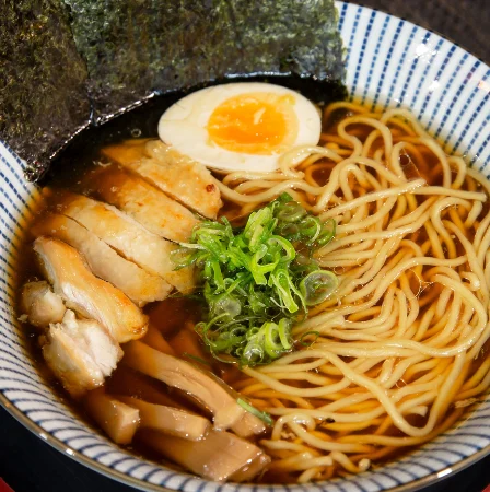 Miojo coreano do tipo lámen com frango, ovo, massa e alga.