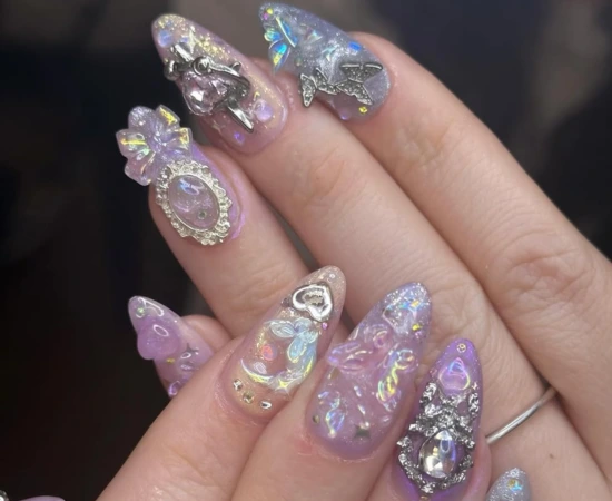 Unhas coreanas Fairycore com estética lúdica, acessórios brilhantes e cores cromadas translúcidas.